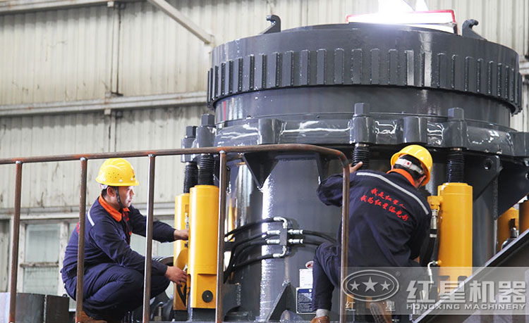 工作人員檢測圓錐破碎機(jī)，保障生產(chǎn)的設(shè)備都有高質(zhì)量